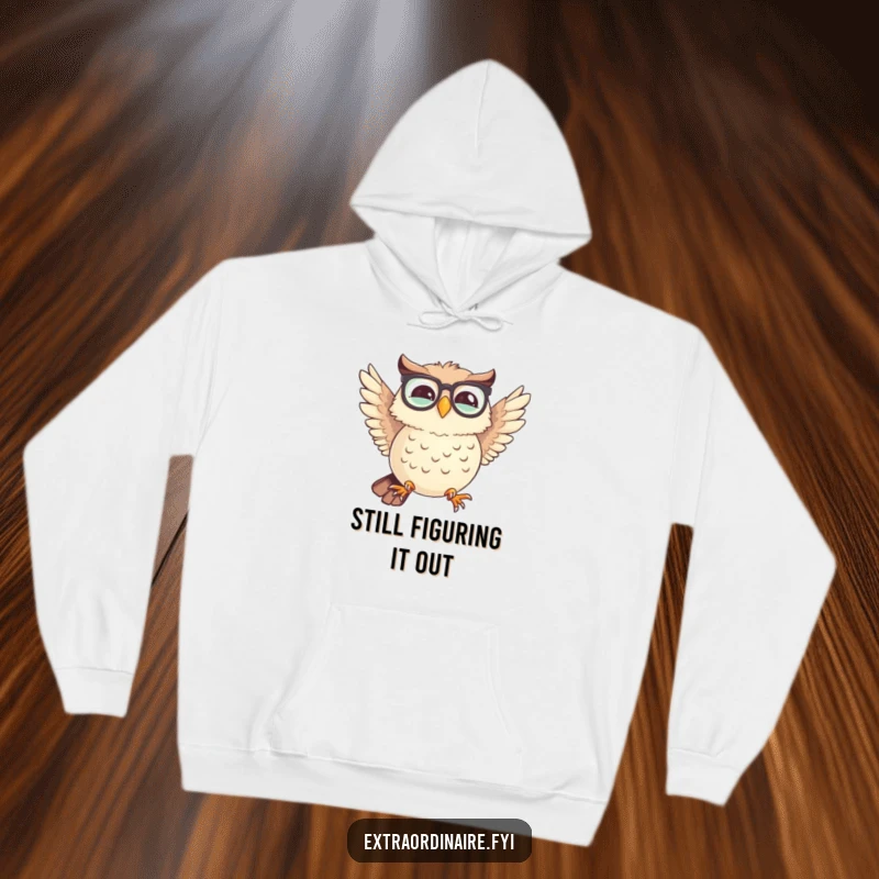 Funny hoodie showing a giggling owl wearing spectacles, comically attempting flight with uneven wings, perfect for cozy humor.